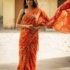 a woman in an orange and white sari