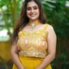 a woman in a yellow dress posing for a picture