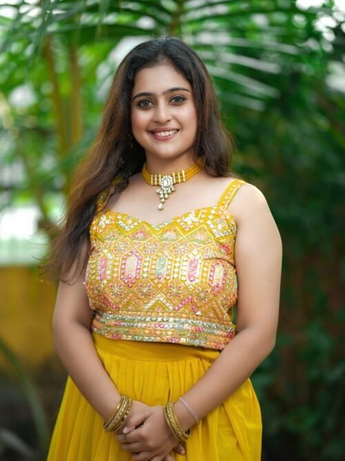 a woman in a yellow dress posing for a picture