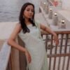 a woman in a dress standing on a bridge over water
